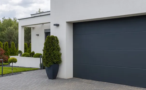 A pair of closed, UPVC double doors in wood decor with a vertical metal handle, set in a stone wall entrance. Smooth stones line the threshold and textured stone surrounds the doorway.